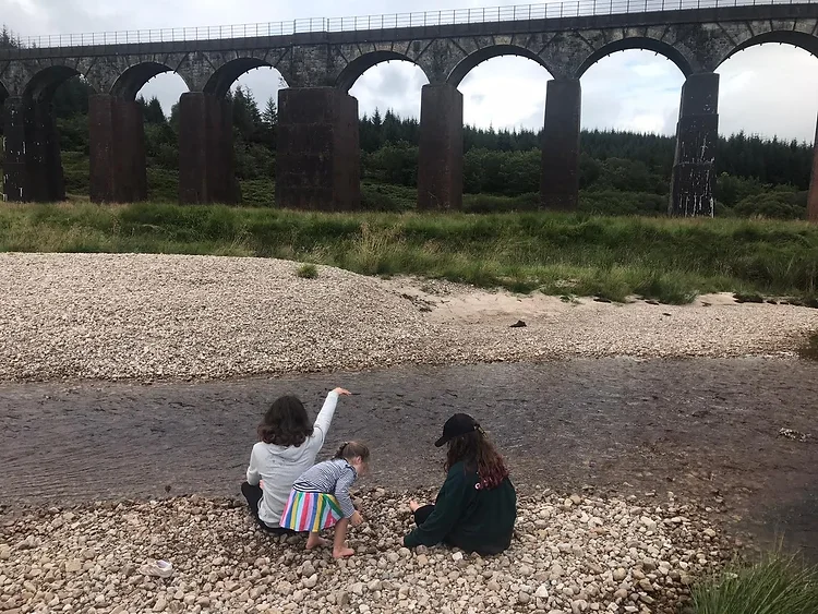 The girls playing next to the river