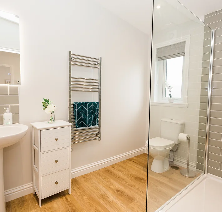 Inside the Silver Birch lodge bathroom, warm hues of wood blend with modern accents, creating a cozy retreat that invites guests to unwind in comfort. Large windows frame views of the surrounding natural beauty, while plush furnishings beckon for moments of relaxation and connection, promising a memorable stay amidst tranquil luxury