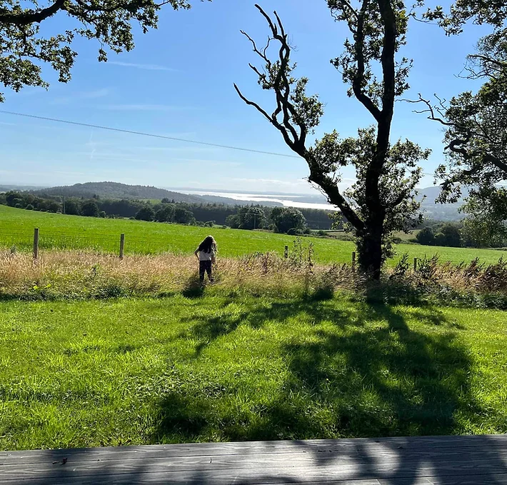 Outside our idyllic lodge, a charming scene unfolds as a young girl plays amidst the splendor of nature. With the majestic hills as a picturesque backdrop, her laughter dances through the air, echoing the joy of carefree moments spent in this enchanting oasis. Surrounded by the beauty of the landscape, she explores with wonder and delight, creating cherished memories against the canvas of rolling hills and endless skies. In this haven of tranquility, every glance outside the window is a reminder of the pure magic that awaits those who embrace the simple joys of life.